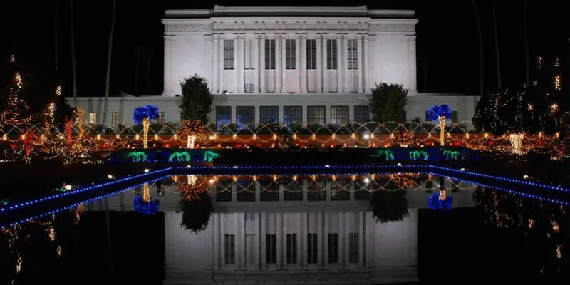 聖誕節期間的梅薩神殿夜景。聖誕樹燈環繞著倒影池、花壇和其他灌木叢。