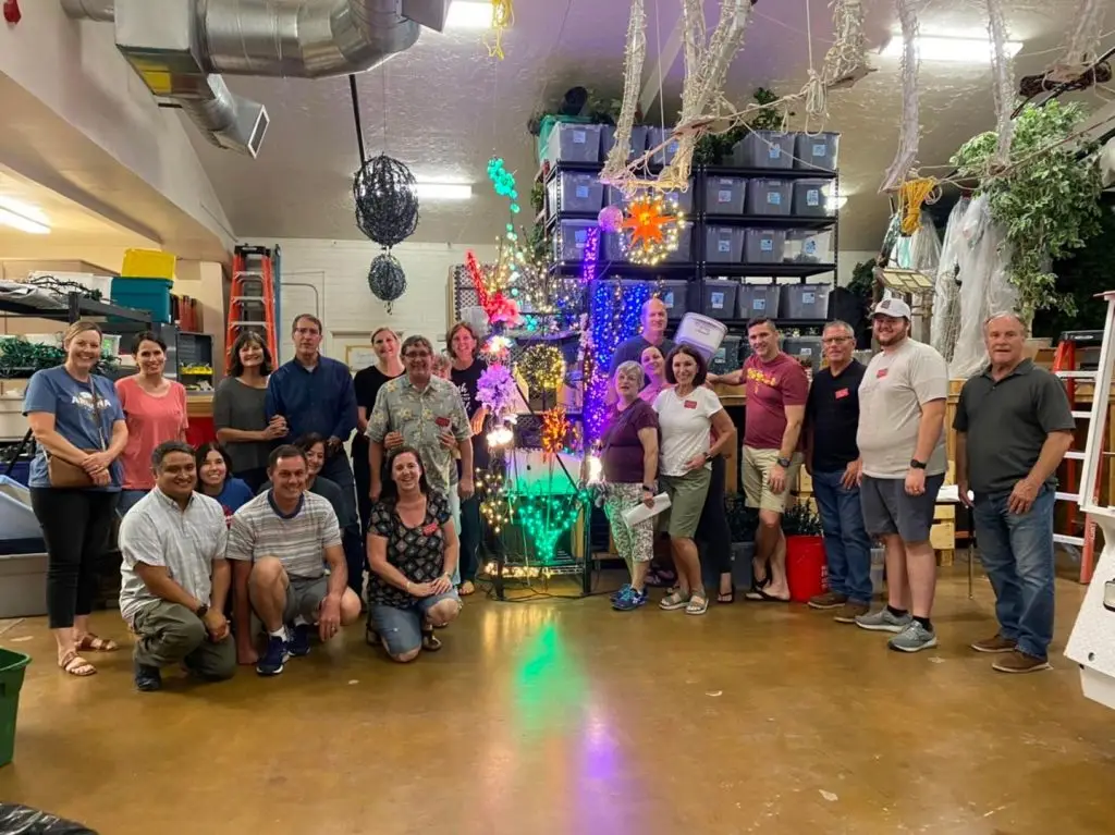 仓库里的几名志愿者帮助安装梅萨圣殿圣诞灯。