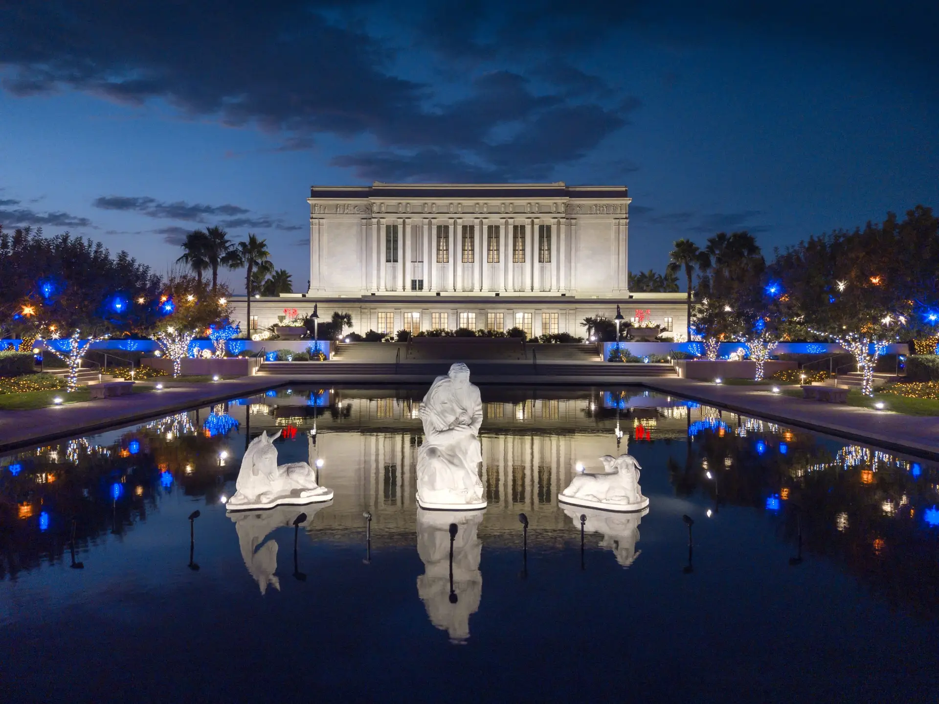 Christmas lights and statues around the reflection pool at the Mesa Temple Grounds at Christmas time.